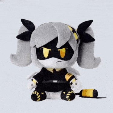 a black and white stuffed animal with a yellow triangle on the bottom