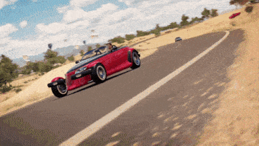 a red car is driving down a curvy road in the desert