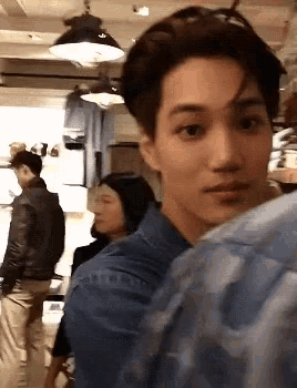 a man in a blue shirt looks over his shoulder