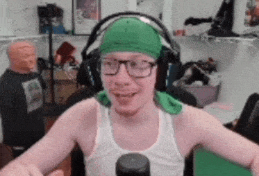 a man wearing a green headband and headphones is sitting in front of a microphone .