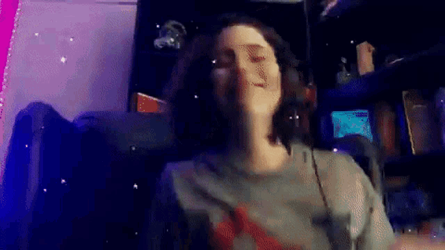 a woman is sitting in a chair with headphones on and dancing .