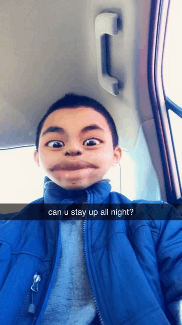 a young boy in a blue jacket is making a funny face and asking can u stay up all night