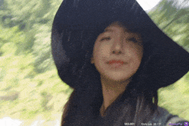 a woman wearing a hat is standing in the rain