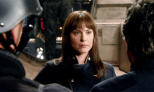 a woman in a military uniform stands between two men