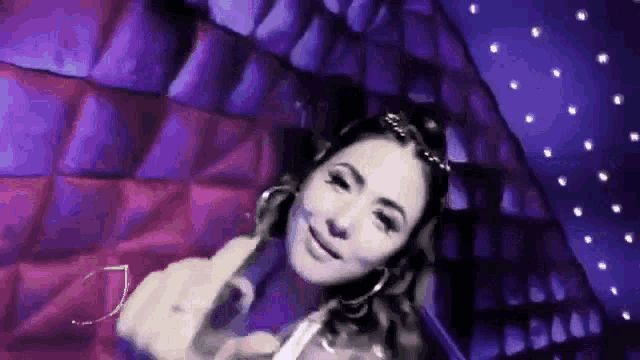 a woman is giving the middle finger to the camera in a dark room .