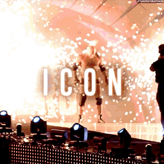a wrestler is standing on a stage with the word icon behind him