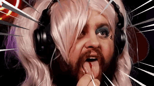 a man wearing headphones and a pink wig has a tattoo on his face