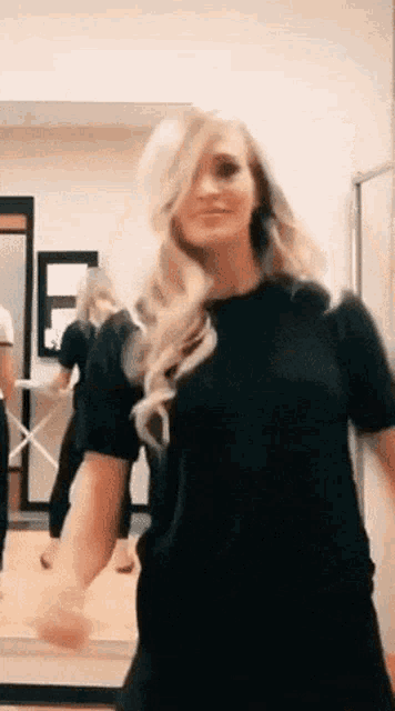 a woman in a black shirt is dancing in a room .