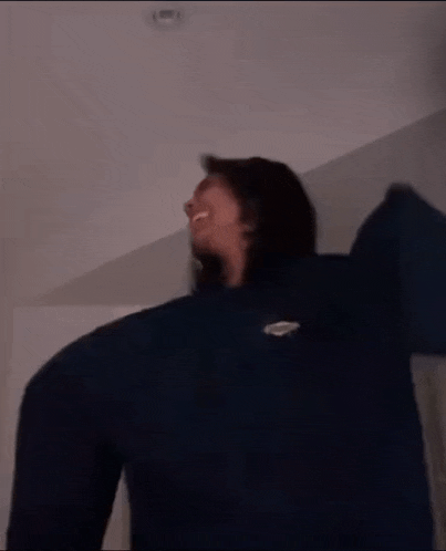 a blurry picture of a person with their arms outstretched in a dark room .