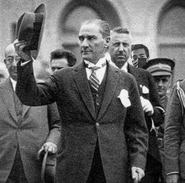 a black and white photo of a man in a suit holding a hat and waving at the camera .