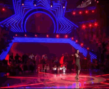 a woman is singing into a microphone on stage
