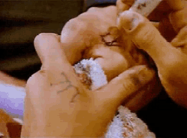 a close up of a person 's hand with a tattoo of the letter t