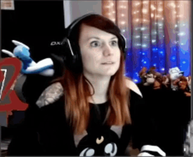 a woman wearing headphones is sitting in front of a computer .