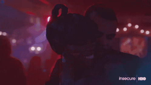a man and a woman are dancing together in a dark room in a club .