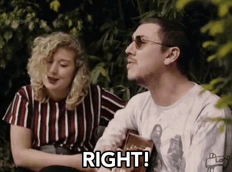 a man and a woman are sitting next to each other and the man is playing a guitar .