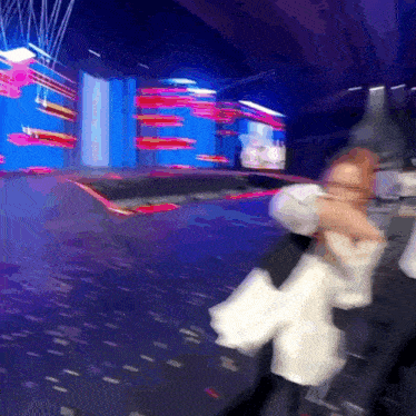 a blurry picture of a person standing on a stage with a blue background