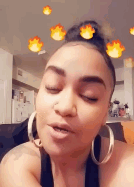 a woman wearing hoop earrings looks at the camera