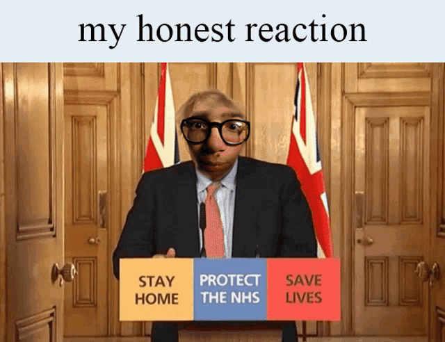 a man in a suit and tie stands at a podium with a sign that says stay home protect the nhs save lives