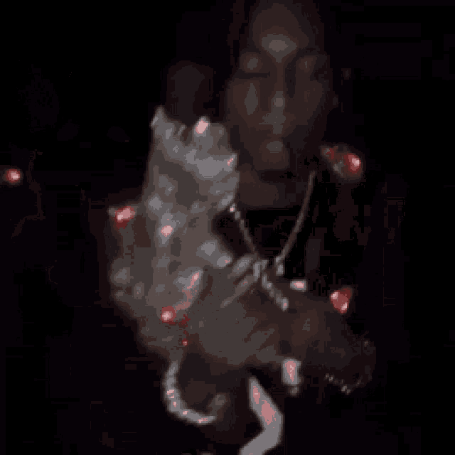 a man is smoking a cigarette in a dark room while holding a bottle of alcohol .