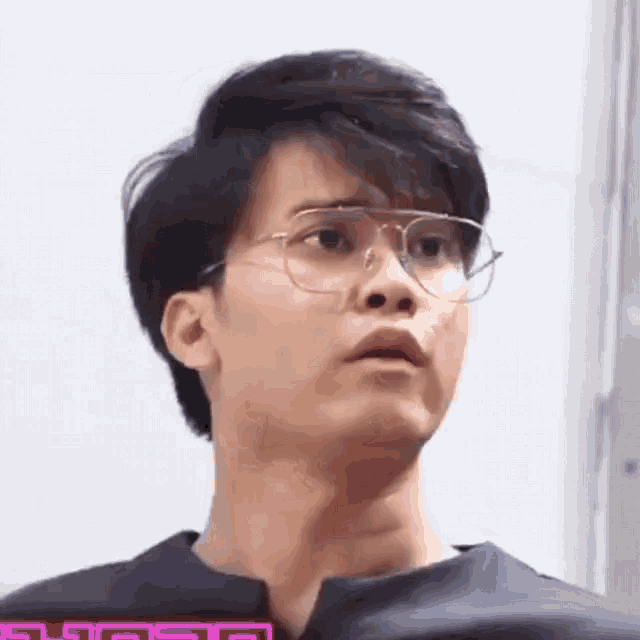 a close up of a man wearing glasses and making a funny face .