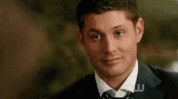 a man in a suit and tie is smiling .