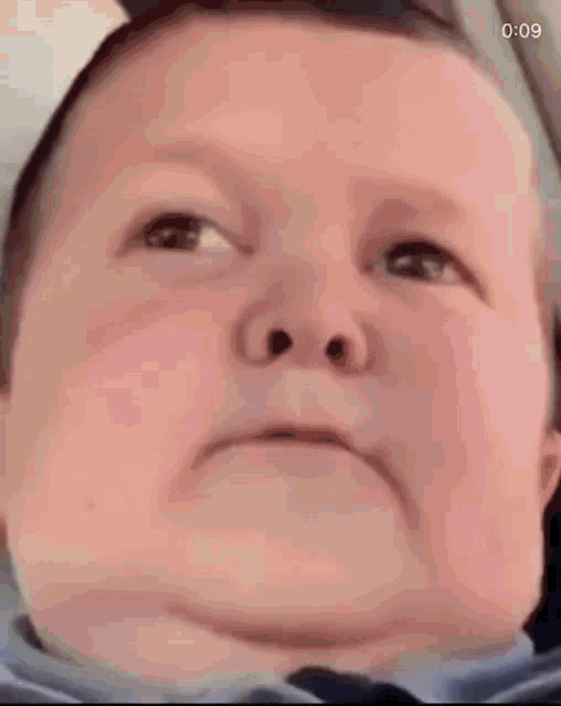 a close up of a baby 's face with a serious look on it .