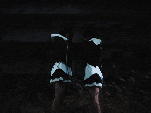 a person in a white shirt is holding a string between their hands