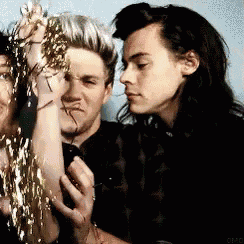 a group of people are standing next to each other and one of them is holding a tinsel .