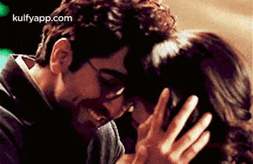 a man and a woman are kissing and hugging each other in a dark room .