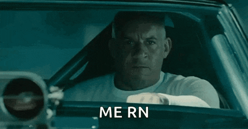 a man is driving a car with the words `` me rn '' written on the window .
