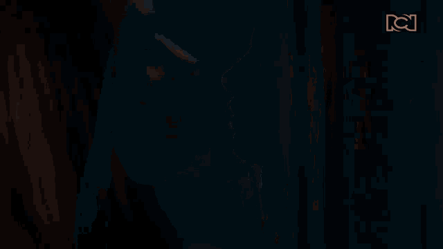 a close up of a woman with her eyes closed in a dark room .