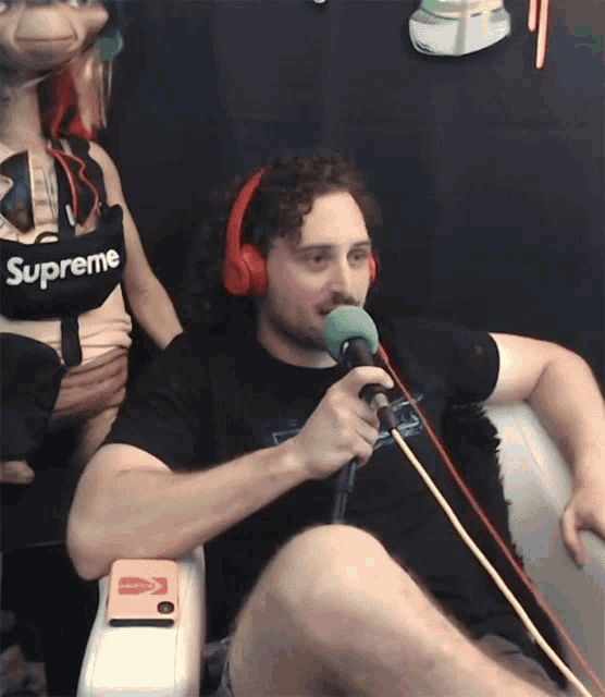 a man wearing headphones and a shirt that says supreme on it
