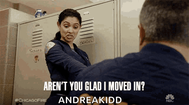 a woman in a blue uniform is talking to a man in front of a locker that says braden on it