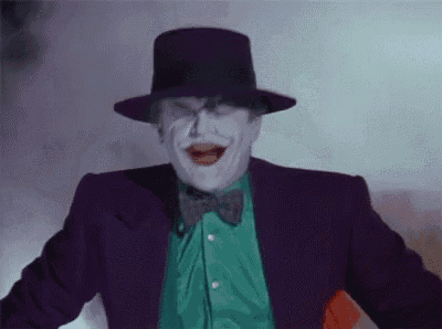 the joker is wearing a purple suit and a top hat .