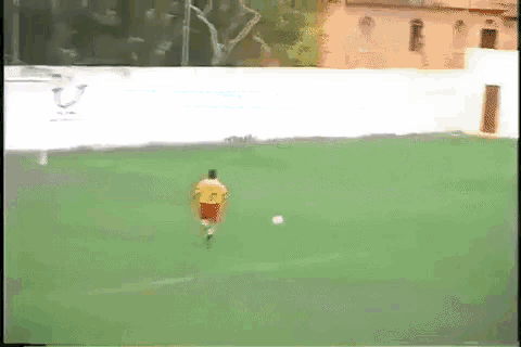 a man in a yellow shirt and red shorts is playing soccer