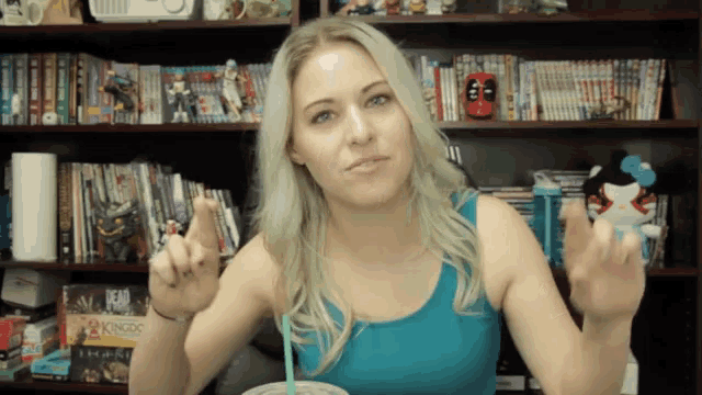a woman sitting in front of a shelf with a game called kingdo on it