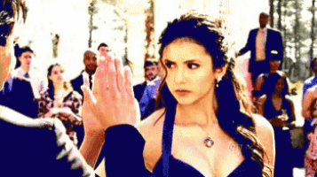 a woman in a black dress is giving a high five to a man in a suit