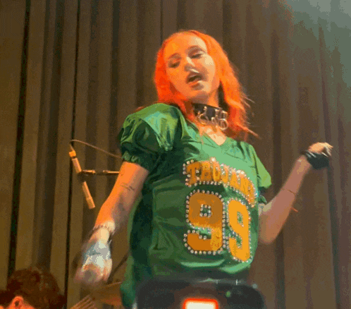 a woman with red hair is wearing a green jersey with the number 39 on it