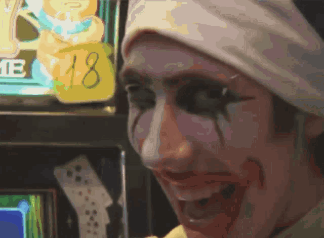 a clown is smiling in front of a sign that says 18 on it