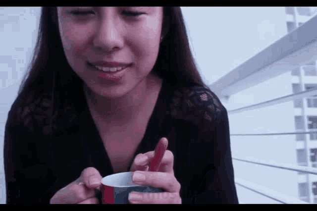 a woman holding a cup with a red straw