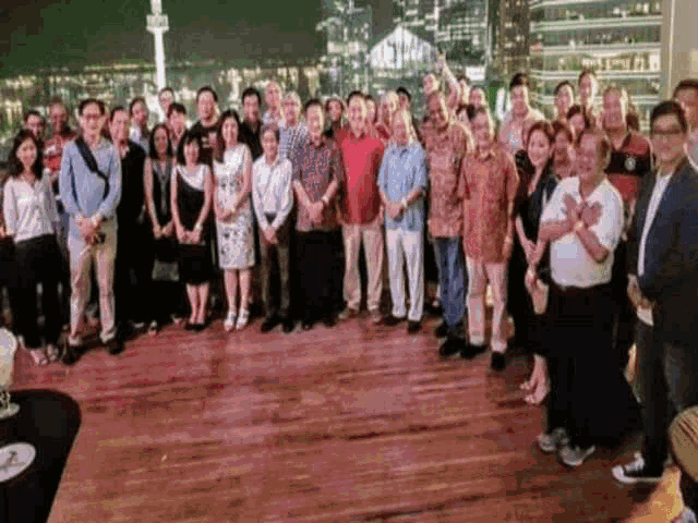 a group of people are posing for a picture on a wooden floor