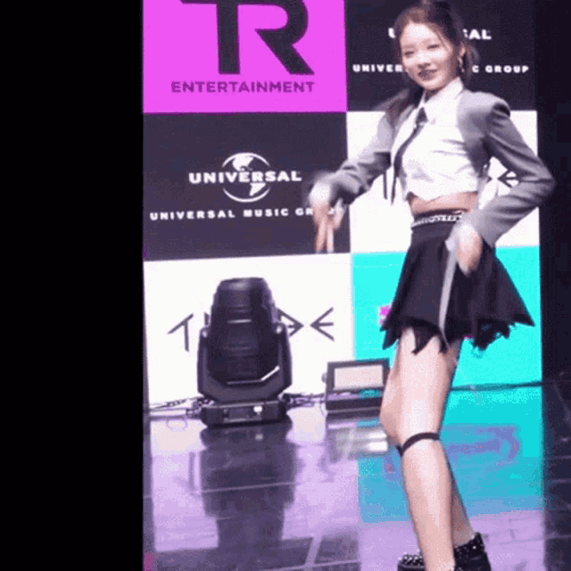 a girl is dancing in front of a sign that says universal entertainment