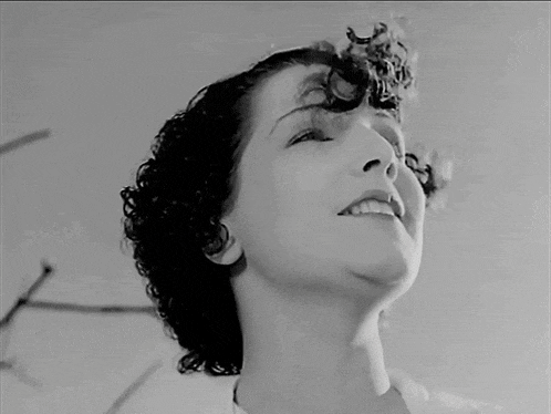 a black and white photo of a woman smiling