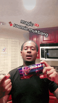 a man is holding a package of magic roomie mukbang in his hands
