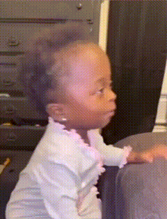 a baby is sitting on a couch looking at something