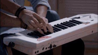 a person is playing a keyboard with a sticker on it that says ' a ' on it