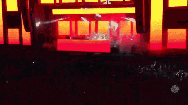 a crowd of people are watching a dj perform on a stage