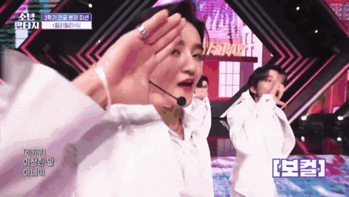 a group of people are dancing on a stage and one of them has a microphone on his head