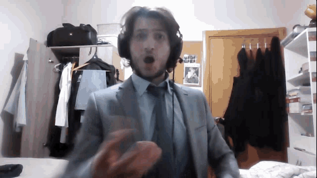 a man in a suit and tie is wearing headphones in a room