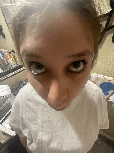 a close up of a woman 's face with a white t-shirt on